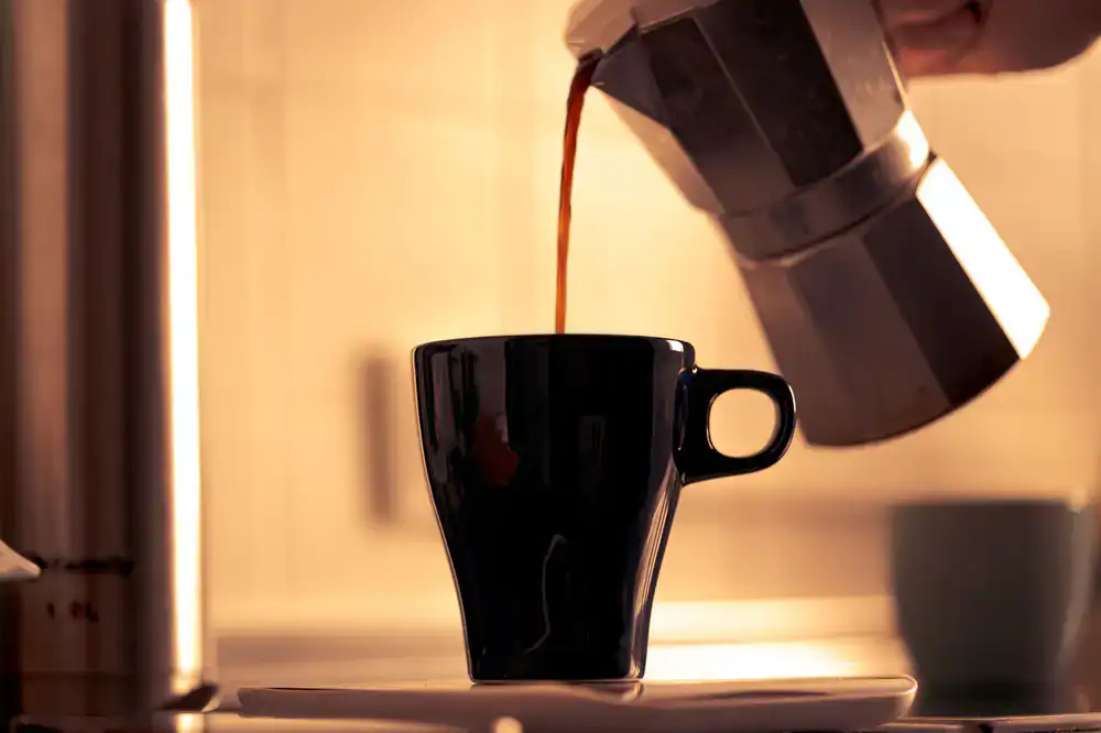 Rich espresso pouring into a ceramic cup