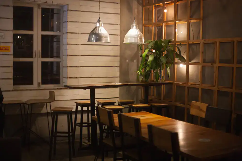 Warm, softly lit interior of the espresso bar with wooden tables