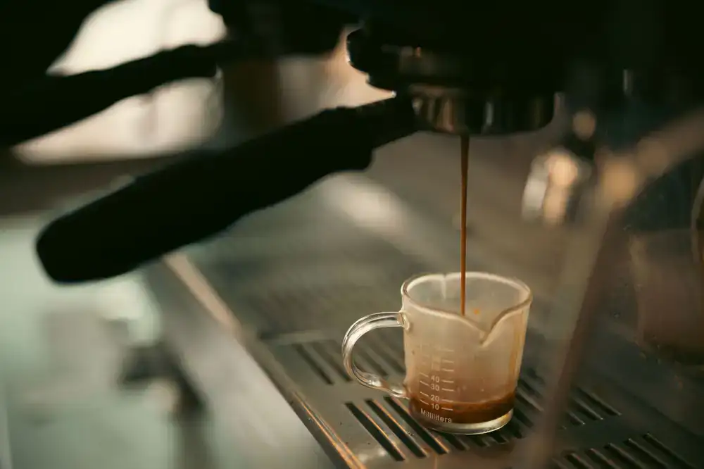 A barista pouring a fresh espresso shot