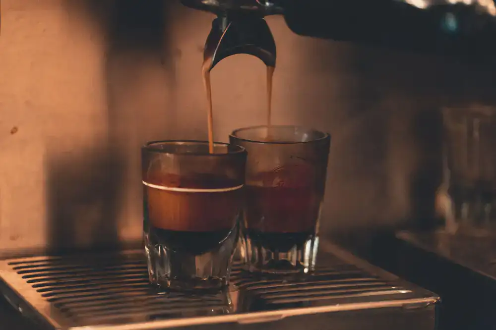 Barista pulling a fresh espresso shot into a ceramic cup