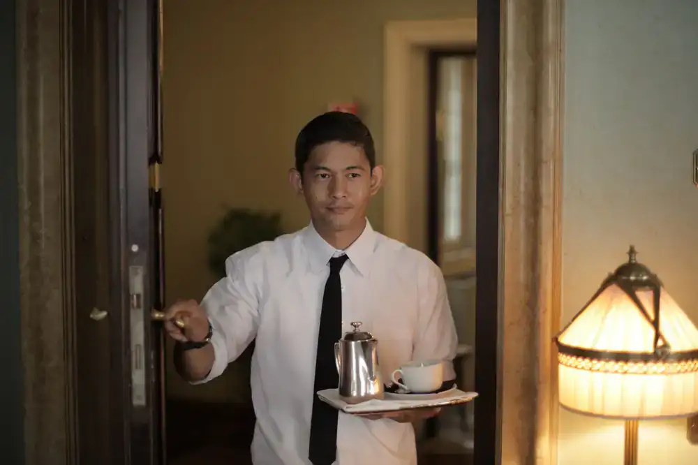 Staff member carrying a tray of cups